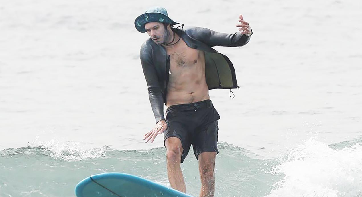 Adam Brody exposed his wide chest while surfing with his wife