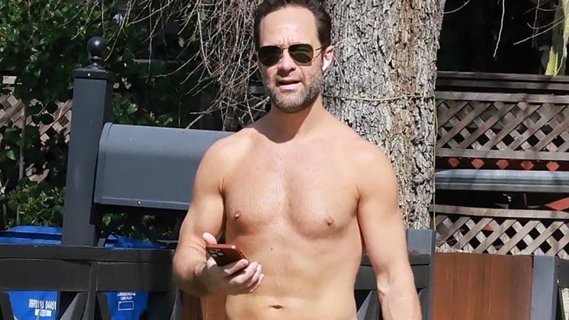 Chris Diamantopoulos flaunts his bare chest while walking his dog